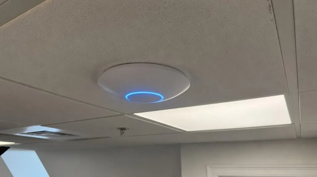UniFi ceiling access point with blue status ring